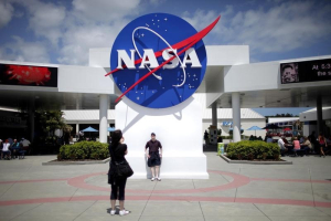 Tourists take pictures of a NASA sign at the Kennedy Space Center visitors complex in Cape Canaveral, Florida April 14, 2010. REUTERS/Carlos Barria <br/>