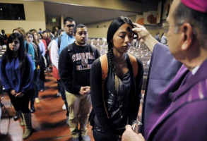 Bishop Armando X. Ochoa of the Roman Catholic Diocese of Fresno, uses ashes to make the sign of the cross on Elisa Martinez, 19, a pre-nursing student, during an Ash Wednesday service at Fresno State’s Satellite Student Union in Fresno, Calif. <br/>