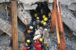 Emergency rescuers remove a body found in a collapsed building from an earthquake in Tainan, Taiwan, Sunday, Feb. 7, 2016. Rescuers on Sunday found signs of live within the remains of the high-rise residential building that collapsed in a powerful, shallow earthquake in southern Taiwan that killed over a dozen people and injured hundreds. (AP Photo/Wally Santana) <br/>