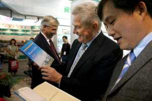 In this file photo, American evangelist and preacher Luis Palau, center, looks at a printed copy of the book he co-wrote with former spokesman for Communist China's Cabinet and atheist Zhao Qizheng, at a bookfair in Beijing, China Aug. 30, 2006. The 140-page work is in part a public relations exercise. Palau wants to reach out to Chinese curious about religion. <br/>AP Images / Elizabeth Dalziel