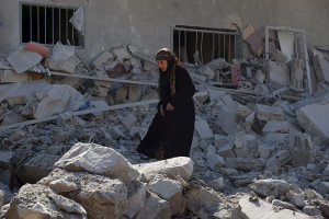 A woman makes her way through the rubble of damaged buildings after airstrikes by pro-Syrian government forces in the rebel held town of Dael, in Deraa Governorate, Syria February 12, 2016. REUTERS/Alaa Al-Faqir <br/>