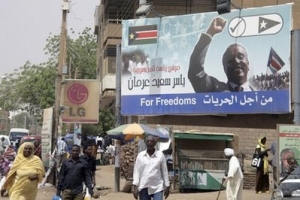 Sudanese walk under a posters supporting one of eleven Sudanese Presidency candidates, Yasser Saeed, in Khartoum, Sudan, Wednesday, March 24, 2010. <br/>AP Images / Abd Raouf