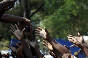 Earthquake survivors reach out as church members distribute small Bibles at a makeshift camp in Port-au-Prince, Thursday, March 11, 2010. The 7.0-magnitude earthquake that hit Haiti on Jan. 12 left more than a million people living in makeshift camps. <br/>AP Images / Esteban Felix