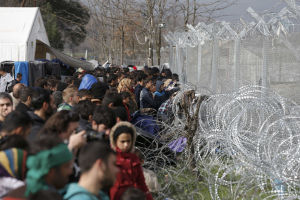 Migrants stand next to the Greek-Macedonian border fence, near the Greek village of Idomenii March 1, 2016.  <br/>REUTERS/Marko Djurica