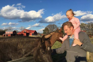 In a photo shared Saturday, Rory Feek, 49, is seen carrying his daughter, Indiana, 2, on his shoulders while he pets a horse. 