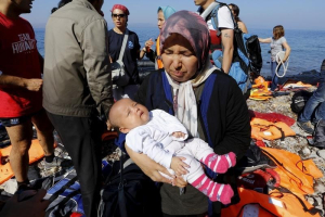 An Afghan refugee holds her three-month-old baby girl Zainab after arriving at a beach on the Greek island of Lesbos after crossing a part of the Aegean sea from Turkey September 17, 2015.  <br/>REUTERS/Yannis Behrakis