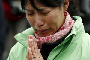 A participant observes a moment of silence at 2:46 p.m. (0546 GMT), the time when the magnitude 9.0 earthquake struck off Japan's coast in 2011, during a rally in Tokyo March 11, 2016, to mark the fifth-year anniversary of the earthquake and tsunami that killed thousands and set off a nuclear crisis.  <br/>REUTERS/Toru Hanai