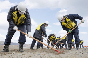 Police officers search for the remains of people who went missing during the March 11, 2011 earthquake and tsunami, in Ishinomaki, Miyagi prefecture, Japan, in this photo taken by Kyodo March 11, 2016, on the five-year anniversary of the disaster. <br/>