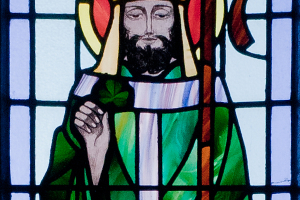 This stained glass window at Saint Benin's Church in Ireland depicts Saint Patrick dressed in a green robe with a halo about his head, holding a shamrock in his right hand and a staff in his left. <br/>Wikipedia/Andreas Borchert