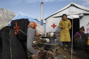A Tibetan family makes a meal outside their tents set up for quake victims in earthquake-hit Yushu county, northwest China's Qinghai province, Monday, April 19, 2010. <br/>Photo/Andy Wong