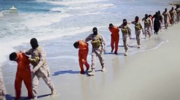 Islamic State militants lead what are said to be Ethiopian Christians along a beach in Wilayat Barqa, in this still image from an undated video made available on a social media website on April 19, 2015. Photo Credit: REUTERS/Social Media Website via Reuters TV <br/>