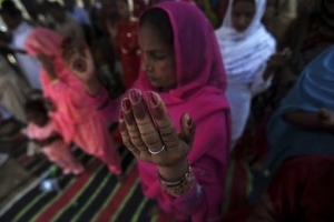 Pakistani Christians, pray during an Easter mass in a church at a Christian neighborhood of Islamabad, Pakistan, Sunday, April 4, 2010. Pakistani Christians account for about 3.8 million of Pakistan's 140 million people. <br/>AP Photo / Muhammed Muheisen