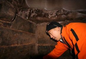 In this undated promotional photo, Panda Lee, one member of a Chinese-Turkish exploration team, examines the 'plank-like timber' inside a structure that the team claims to be Noah's Ark. <br/>Noah's Ark Ministries International