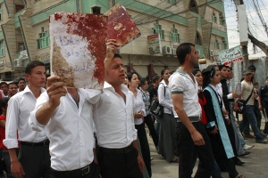 Iraqi Muslims and Christians hold blood-stained notebooks as they march to denounce a bombing that targeted buses carrying Christan students, near Mosul, 225 miles (360 kilometers) northwest of Baghdad, Monday, May 3, 2010. Two bombs exploded minutes apart Sunday near buses carrying Christian students in the northern Iraqi city of Mosul, killing at least one bystander and injuring around 100 others, a security official said. <br/>AP Photo