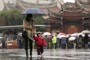 A mother walks with her son in the rain after offering prayers at a local temple for the Chinese Lunar New Year in Taipei, Taiwan, Wednesday, February 17, 2010. <br/>AP