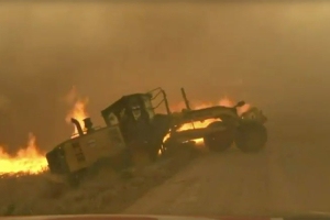 An Oklahoma news team saved a man from a raging wildlife inferno when he became stuck in a ditch while trying to cut a fire line from on his road grader.  <br/>YouTube