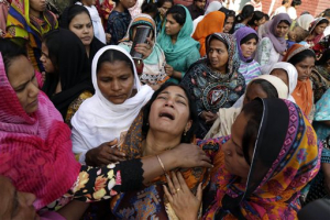 People try to comfort a Pakistani Christian mother during the funeral of her two daughters, killed in a suicide bombing Sunday, in Lahore, Pakistan, March 30. The massive suicide bombing by a breakaway Taliban faction targeted Christians gathered for Easter Sunday in a park in Lahore, killing more than 70 people. (AP Photo/K.M. Chaudary) <br/>