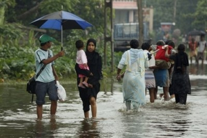 Sri Lankans wade through a submerged road in Colombo, Sri Lanka, Friday, May 21, 2010. Sri Lankan government says that 19 people have died in floods, earth slips and hazards caused by strong winds during a week of heavy rain across the country. <br/>AP Photo / Eranga Jayawardena