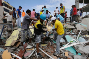 Volunteers remove a body from a destroyed house in Pedernales, Ecuador, on April 17. (Dolores Ochoa/AP) <br/>