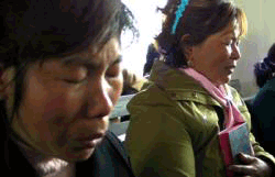 Women weeping and praying after receiving Bibles during a visit to their village church by the Bible and medical van <br/>