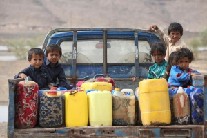 Children ride on the back of a truck loaded with water jerrycans at a camp for internally displaced people in the Dhanah area of the central province of Marib, Yemen, April 30, 2016. REUTERS/Ali Owidha <br/>