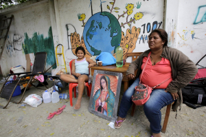 A woman and her daughter rest next to an image of the Virgin of Guadalupe outside their home in Pedernales, after an earthquake struck off the Pacific coast, April 20, 2016. REUTERS/Henry Romero <br/>