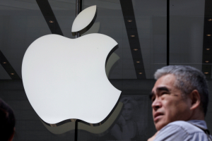 A man stands below the Apple logo at the third Apple Store in Shanghai, China September 21, 2011. REUTERS/Aly Song/File Photo <br/>REUTERS