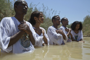 Eritrean Christian migrants now living in Israel pray in the waters of the Jordan River at the Qasr al-Yahud baptism site <br/>Photo: Wall Street Journal