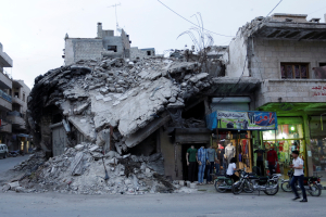 A clothing shop displays its merchandise beside a damaged building in the rebel-controlled area of Maaret al-Numan town in Idlib province, Syria, May 15, 2016. REUTERS/Khalil Ashawi <br/>