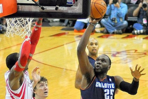 Al Jefferson takes a shot during his first regular season game as a member of the Charlotte Bobcats, October 30, 2013, versus the Houston Rockets at the Toyota Center in Houston, Texas. Defending for the Rockets are Dwight Howard (arms raised) and Omer Asik. <br/>Wikimedia Commons/Pkantz