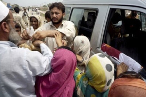 Pakistani flood victims receive food provided by a volunteer in Dera Ismail Khan, Pakistan on Sunday, Aug. 1, 2010. <br/>AP Images / Ishtiaq Mahsud
