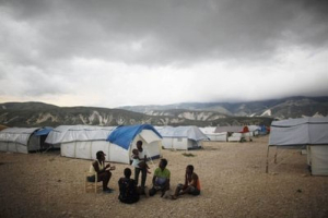 In this photo taken May 31, 2010, people sit in the Corail-Cesselesse camp for earthquake displaced people on the outskirts of Port-au-Prince, Haiti. <br/>AP Images / Alexandre Meneghini