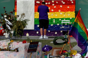 A man pays respect at a rainbow flower wall as part of the makeshift memorial for the Pulse nightclub mass shooting victims last week in Orlando, Florida, U.S., June 21, 2016.  <br/>REUTERS/Carlo Allegri