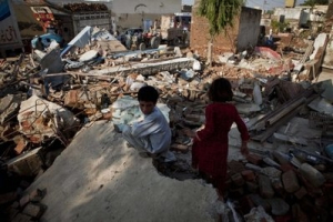 Pakistani children sit over a rubble of their house destroyed by heavy floods in Nowshera in northwestern Pakistan on Wednesday, Aug. 4, 2010. This year's monsoon season has prompted the worst flooding in Pakistan in living memory and already killed more than 1,500 people, official said. <br/>AP Photo / B.K.Bangash