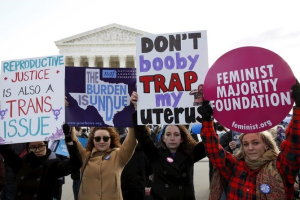 Protesters hold signs in front of the U.S. Supreme Court on the morning the court takes up a major abortion case focusing on whether a Texas law that imposes strict regulations on abortion doctors and clinic buildings interferes with the constitutional right of a woman to end her pregnancy, in Washington March 2, 2016.  <br/>REUTERS/Kevin Lamarque