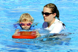 Photo of a woman teaching a child how to swim.  <br/>Pixabay/White77