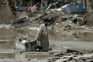 A flood survivor wades through mud as he salvages belongings in Azakhel, near Nowshera, northwest Pakistan, Saturday, Aug. 14, 2010. A case of the deadly waterborne disease cholera has been confirmed in Pakistan's flood-ravaged northwest, and aid workers expect there to be more, the U.N. said Saturday. The discovery came as new flood surges hit the south and the prime minister said the deluge has made 20 million people homeless. <br/>AP/Aaron Favila