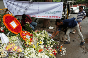 People place flowers at a makeshift memorial near the site, to pay tribute to the victims of the attack on the Holey Artisan Bakery and the O'Kitchen Restaurant, in Dhaka, Bangladesh, July 5, 2016. <br/> REUTERS/Adnan Abidi