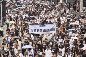 Ten of thousands of people march through a downtown street in Hong Kong yesterday in honor of victims of the Manila bus hijacking and in lingering outrage over the bloodshed. The bloody end to the incident stunned Hong Kongers, who blasted Manila police for what they called an amateurish rescue attempt. The words on the banner read: <br/>Shanghai Daily