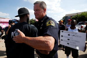 A Dallas police officer hugs a man following a prayer circle after a Black Lives Matter protest following the multiple police shootings in Dallas, Texas, U.S., July 10, 2016.  <br/>REUTERS/Carlo Allegri