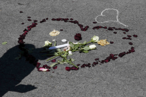 A shadow is cast on flower petals that form a heart placed on the road in tribute to victims of the truck attack along the Promenade des Anglais on Bastille Day that killed scores and injured as many in Nice, France, July 17, 2016.  <br/>REUTERS/Pascal Rossignol