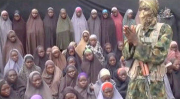 A still image from a video posted by Nigerian Islamist militant group Boko Haram on social media, seen by Reuters on August 14, 2016, shows a masked man talking to dozens of girls the group said are school girls kidnapped in the town of Chibok in 2014.  <br/>Social Media