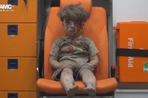A still image taken on August 18, 2016 from a video posted on social media said to be shot in Aleppo on August 17, 2016, shows a boy with bloodied face sitting in an ambulance, after an airstrike, Syria.  <br/>Social Media