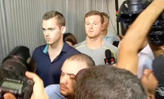 U.S. swimmers Jack Conger and Gunnar Bentz walk out of Rio de Janeiro's international airport after they were stopped from boarding a flight. <br/> TV Bandeirantes/Handout via REUTERS