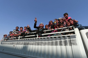 Women and children celebrate on top of a pickup truck after they were evacuated <br/>Reuters