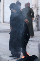 A woman sets fire to a niqab. <br/>Reuters