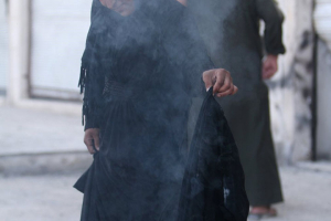 A woman sets fire to a niqab. <br/>Reuters