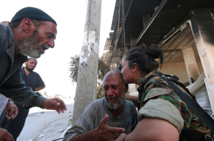 An SDF fighter comforts a distraught man after the evacuation.<br />
 <br/>Reuters