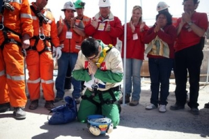 In this photo released by the Chilean government, miner Esteban Rojas, 44, gets on his knees to pray after being rescued from the collapsed San Jose gold and copper mine, near Copiapo, Chile, Wednesday, Oct. 13, 2010. Rojas was the eighteenth of the 33 miners rescued from the mine after more than two months trapped underground. <br/>Chilean government / Hugo Infante