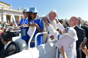 Pope Francis receives a garland from a nun of Mother Teresa's Missionaries of Charity during the audience for workers ad volunteers of Mercy at the Vatican, September 3, 2016.  <br/>Osservatore Romano/Handout via REUTERS 